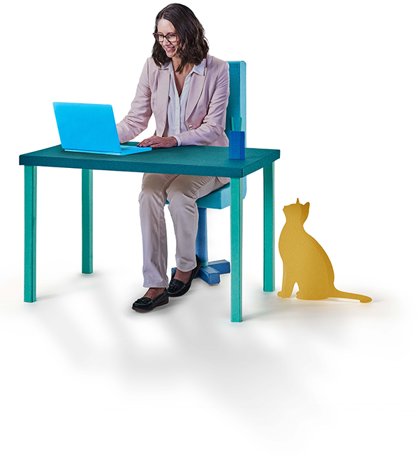 Woman sat at a desk looking at a laptop, with a cat sat next to the desk