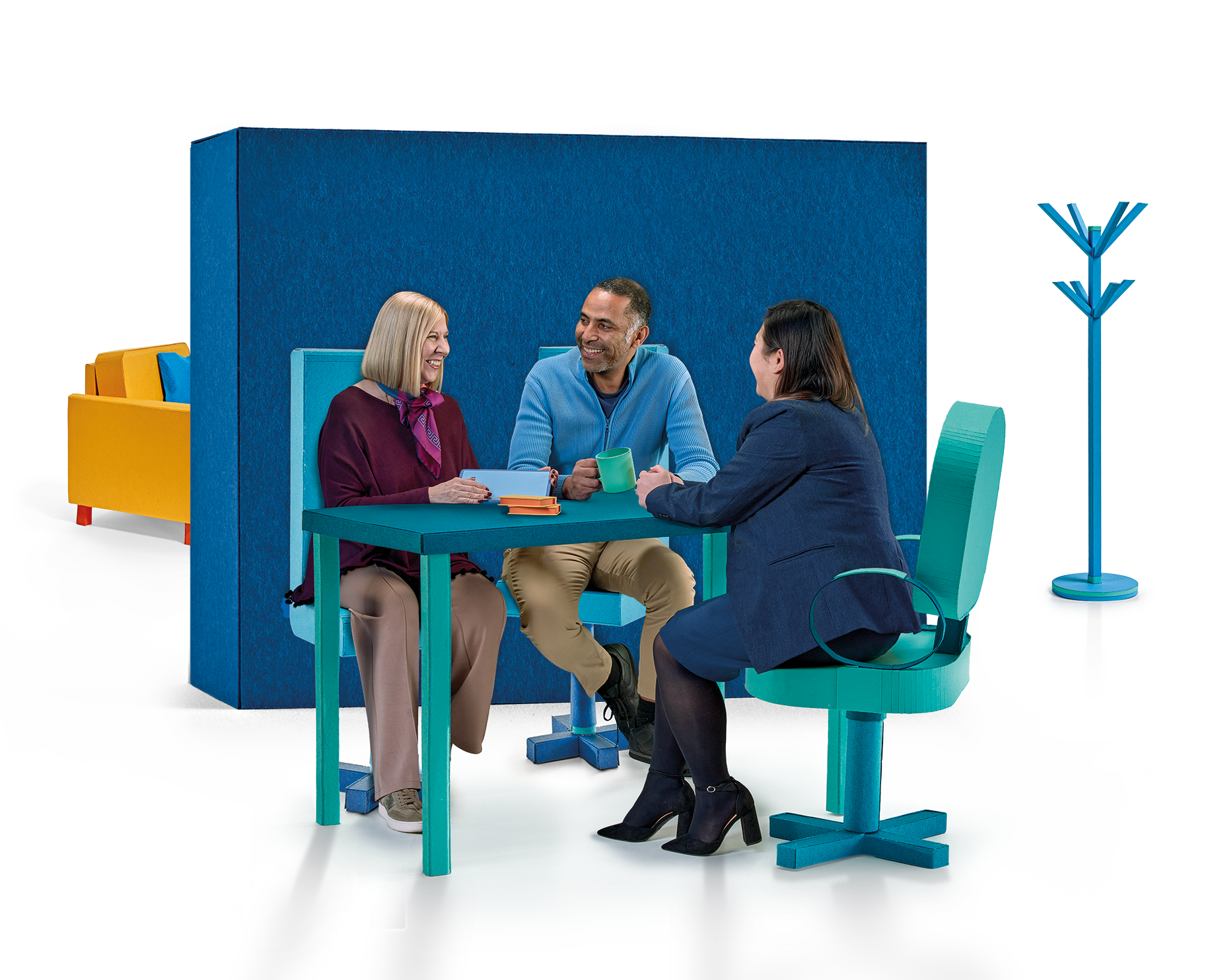 Two women and a man sitting aorund a coffee table talking 