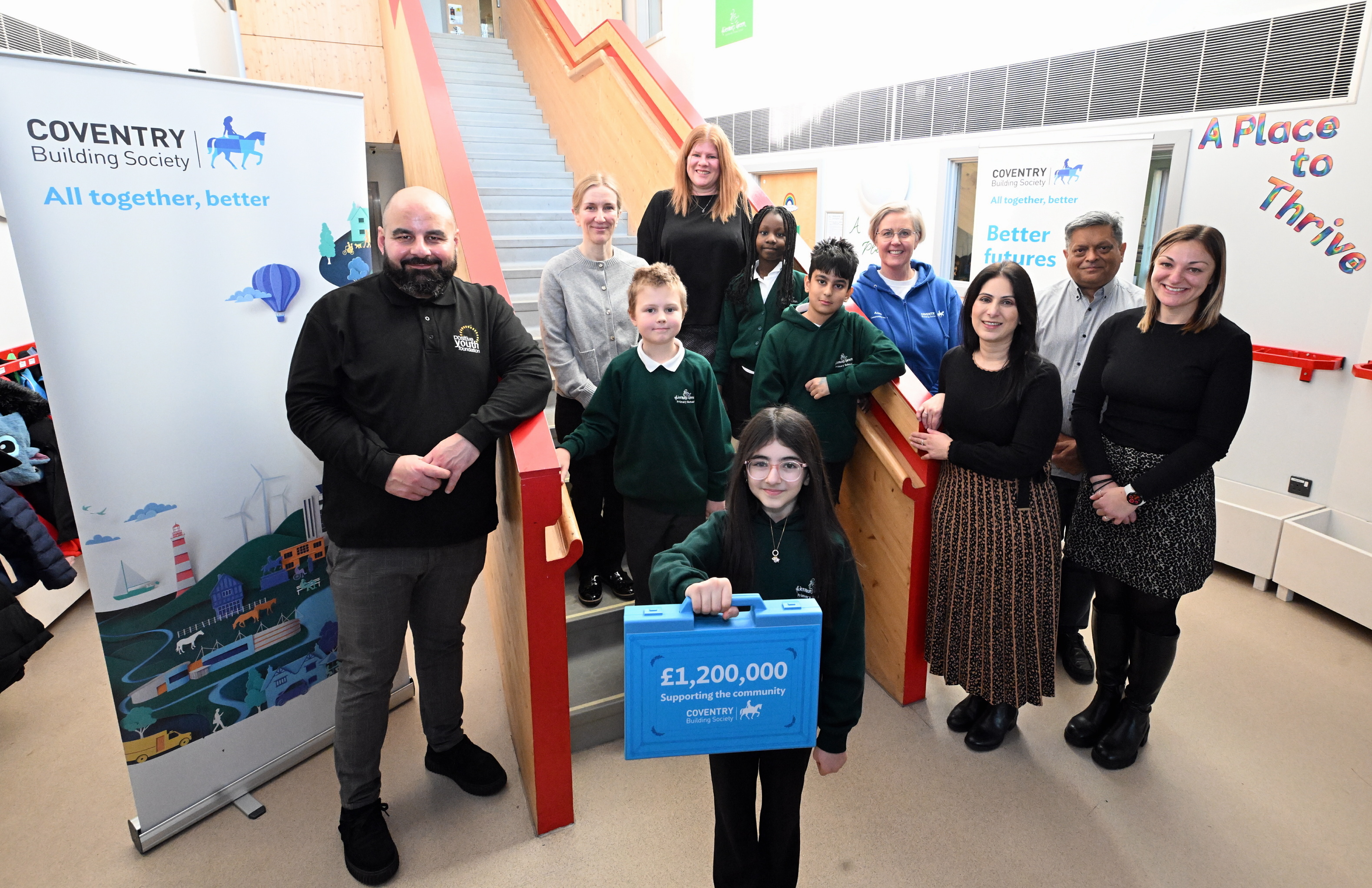 Image of a group of kids in school uniform stood on stairs next to a Coventry Building Society sign