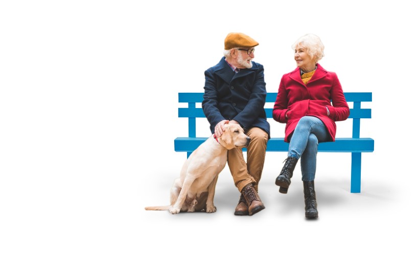 Elderly couple sat on a bench with their Labrador puppy