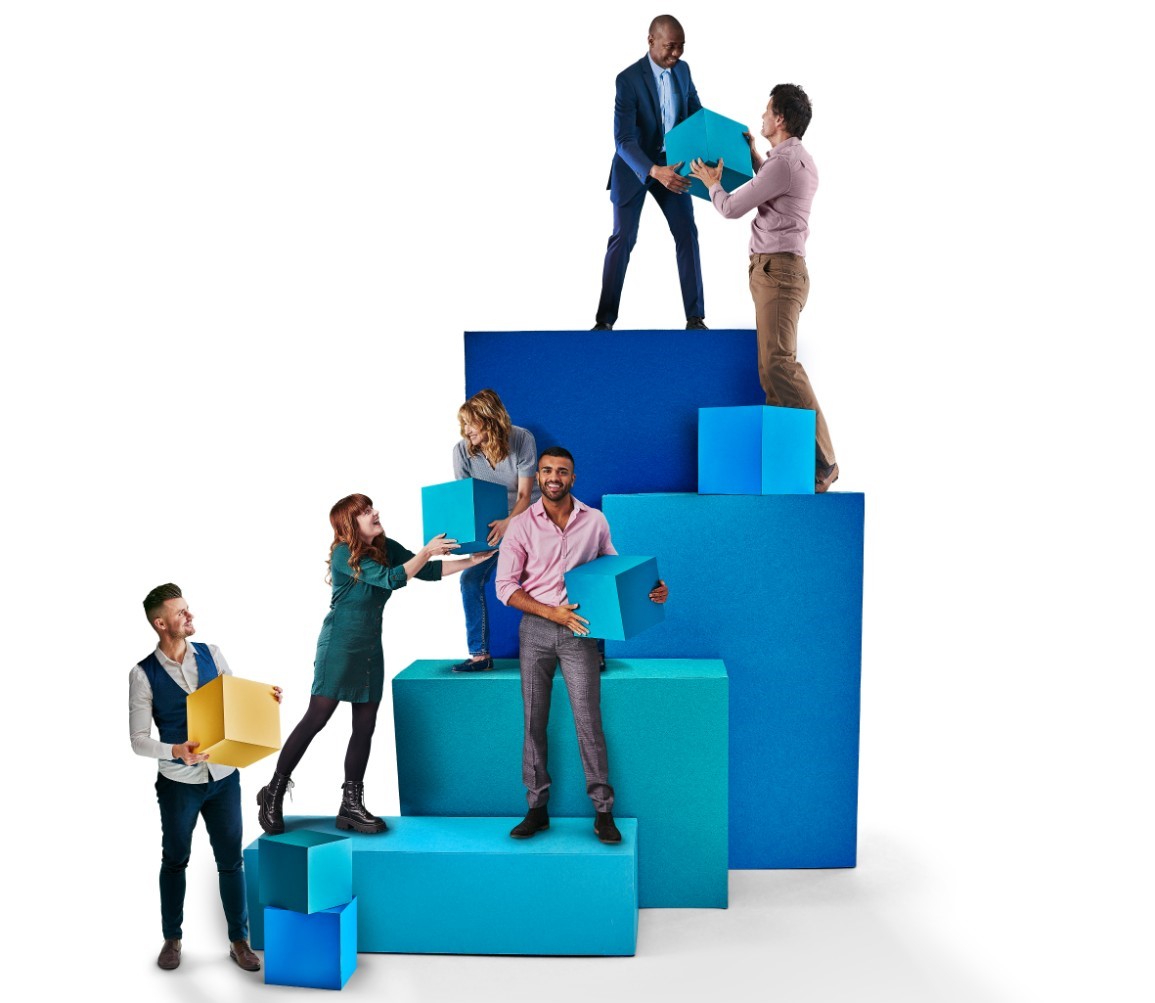Image of a group of people stood on big blue boxes passing parcels to one another 