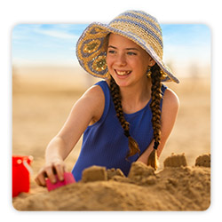Image of a girl at the beach wearing a sunhat